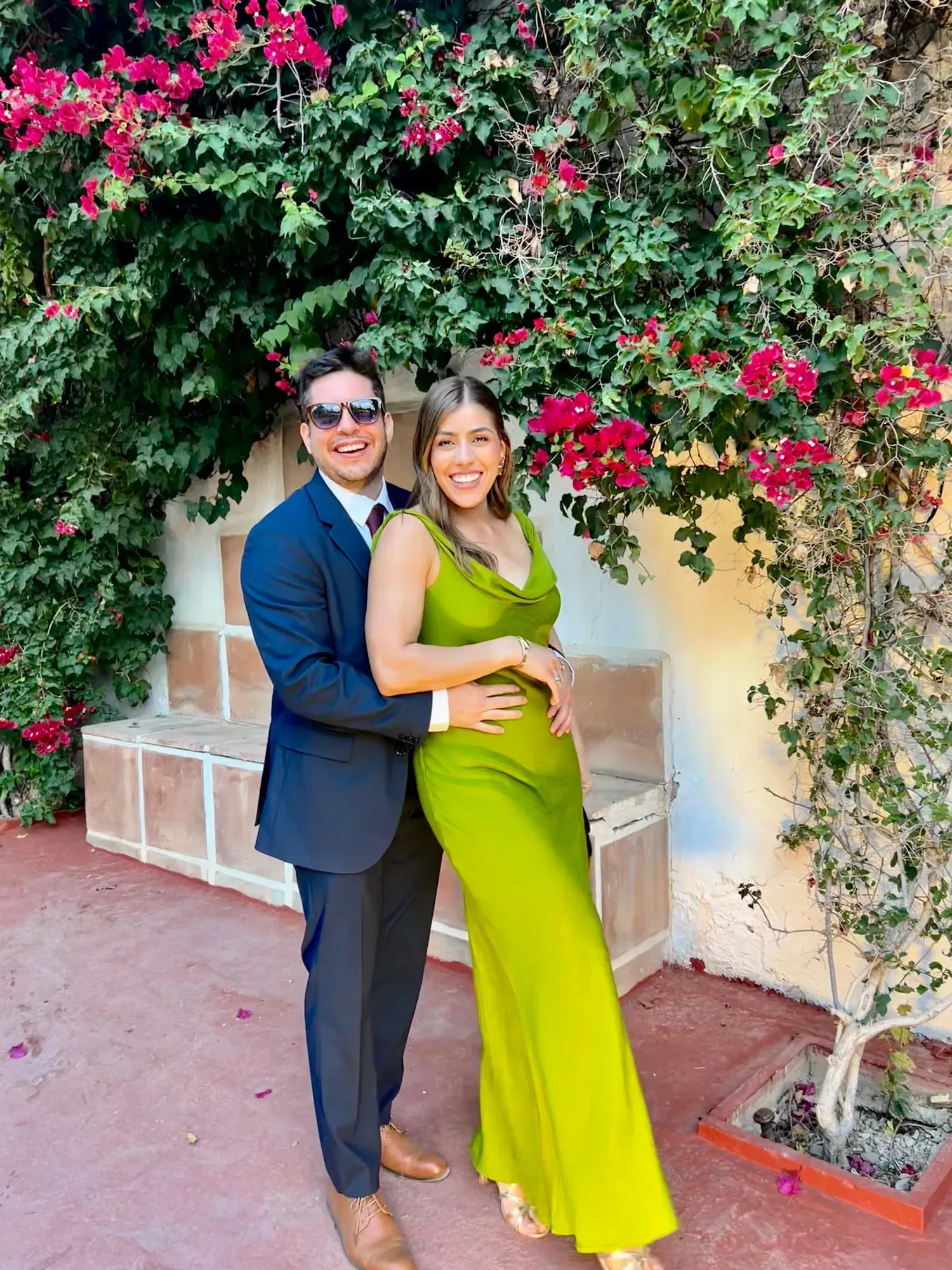 Claudia y Daniel abrazados bajo una buganvilla en flor
